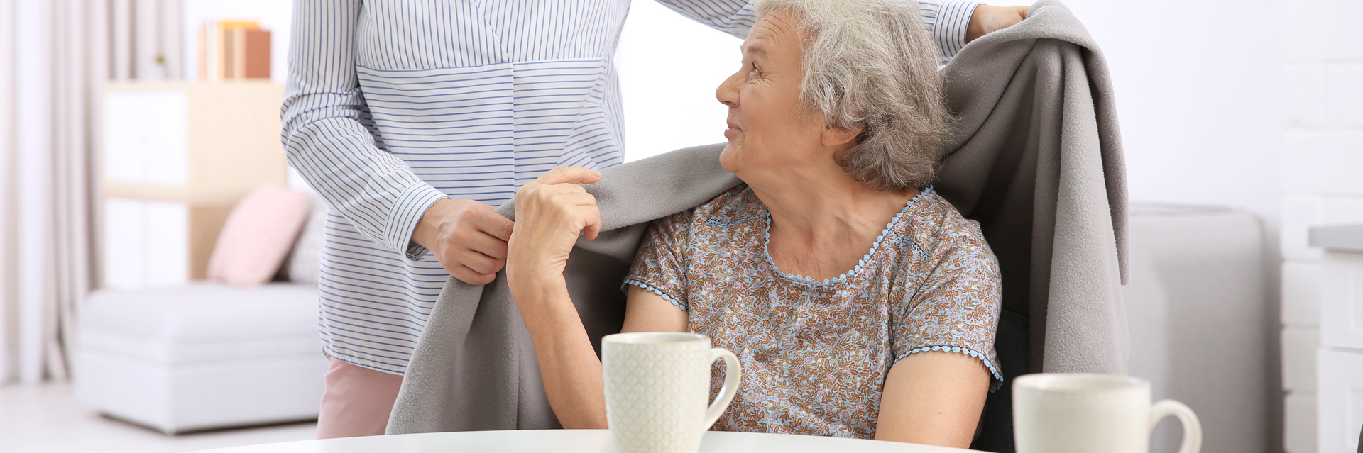 Caregiver sitting with an elderly client at home